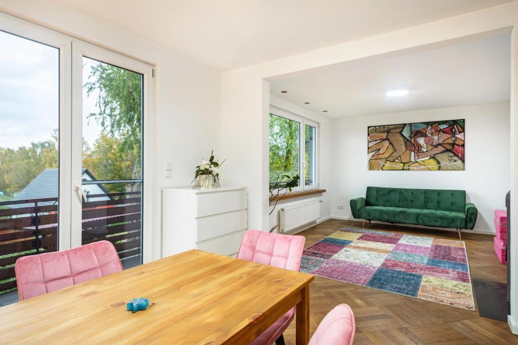uma sala de estar com uma mesa e um sofá verde em Deine Traumwohnung em Bad Saulgau