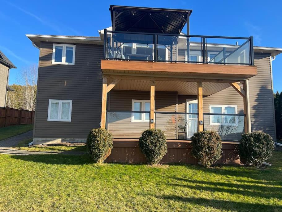 a house with a balcony on top of it at Waterfront cozy cottage. in Port Perry
