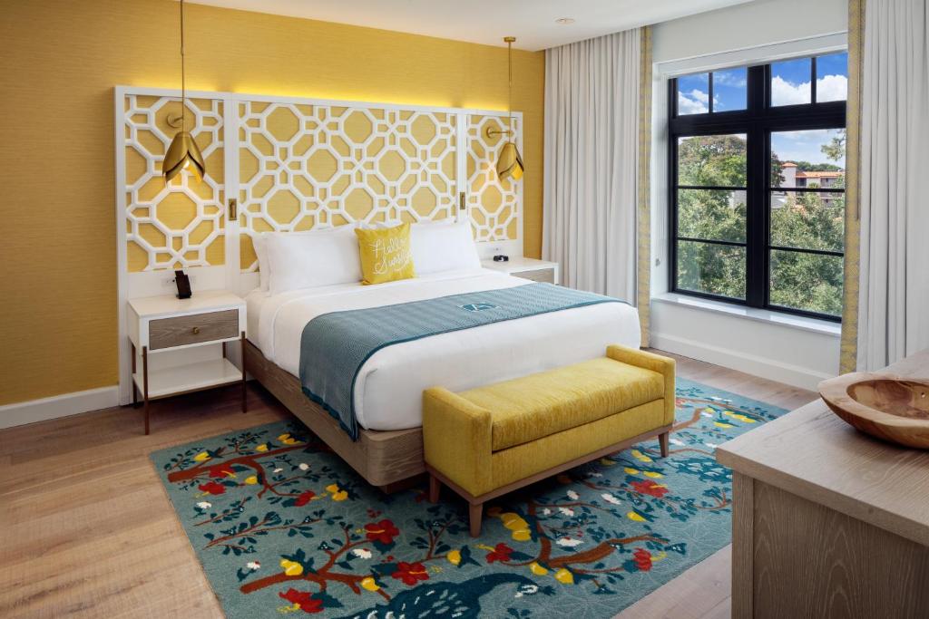 a bedroom with a large bed and a yellow wall at The Alfond Inn in Orlando