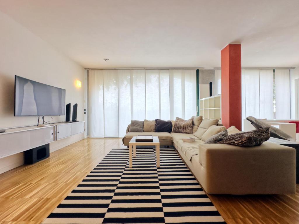 a living room with a couch and a flat screen tv at Arzignano Charm: Modern Home With Parking! in Arzignano