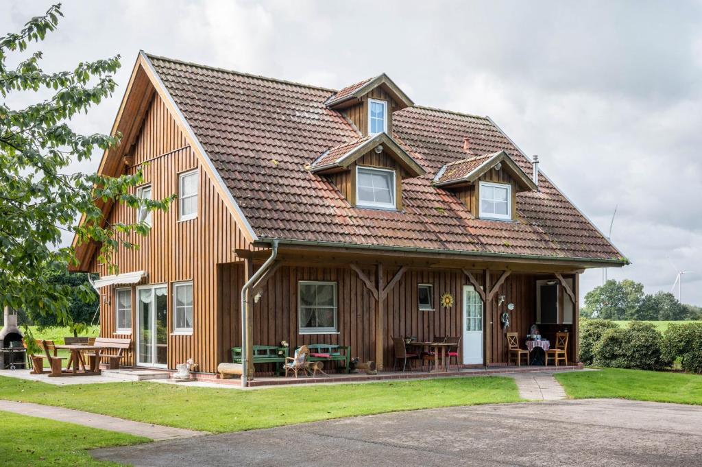 een groot houten huis met een gambrel dak bij Großes Gästehaus in Sudwalde