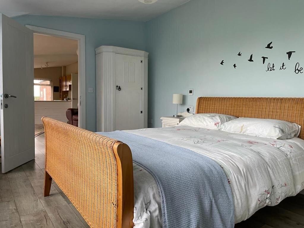 a bedroom with a large bed with a blue wall at Let It Be in Liverpool