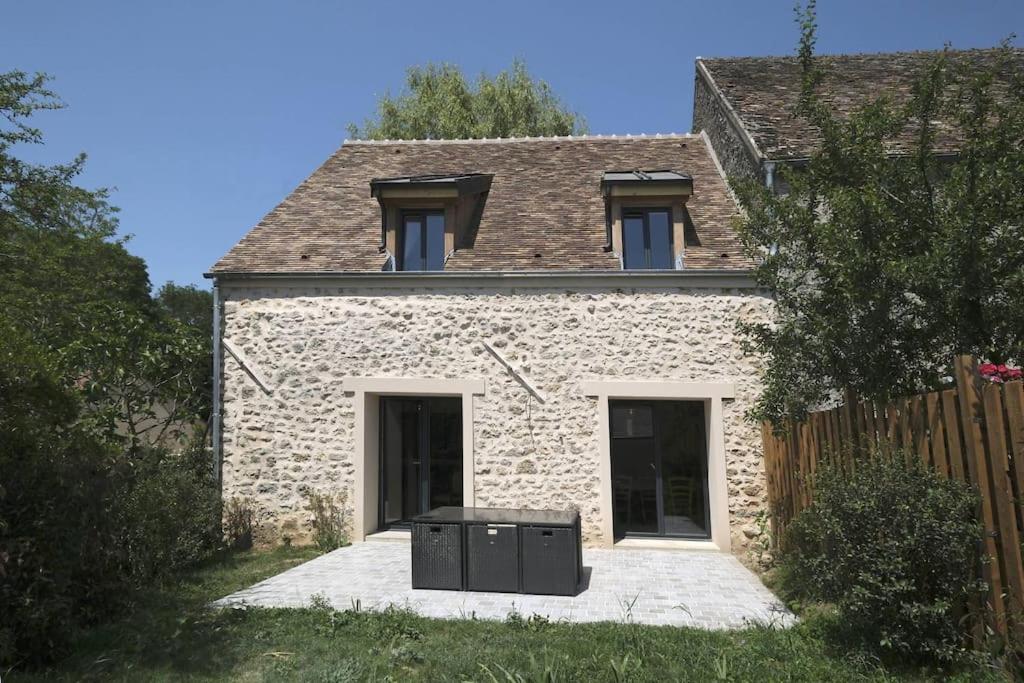 ein Steinhaus mit Grill davor in der Unterkunft Le Gîte - Le Pressoir in Les Molières