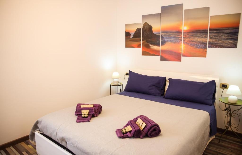 ein Schlafzimmer mit einem Bett mit drei Gemälden an der Wand in der Unterkunft [Free Parking & Wi-Fi] 5 min to Hospital Cisanello in Pisa