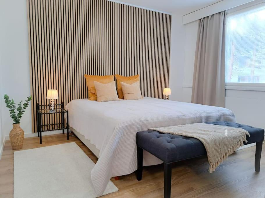 Un dormitorio con una gran cama blanca y una ventana. en Seaside apartment, en Rauma