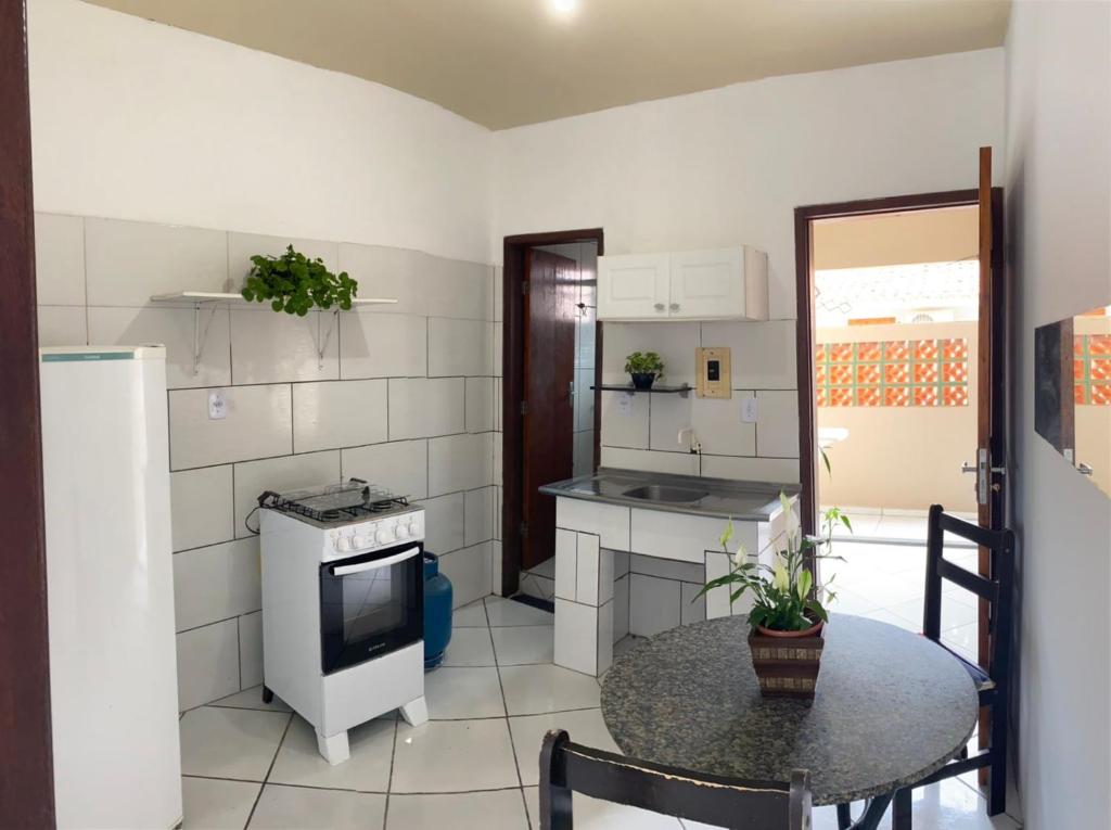 eine kleine Küche mit einem Tisch und einem Herd in der Unterkunft Casa para temporada, Florianópolis in Florianópolis