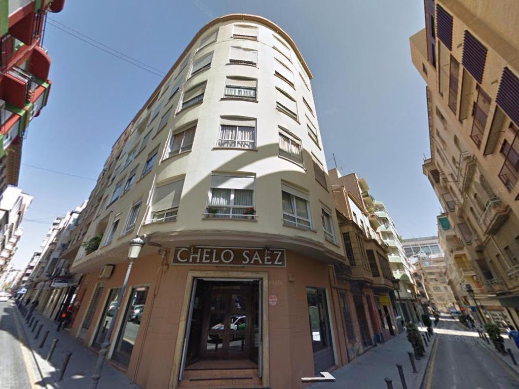 un edificio blanco alto con un letrero. en Atico Cesar Elguezabal, en Alicante