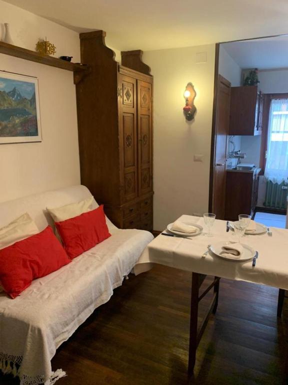 um quarto com uma cama e uma mesa com almofadas vermelhas em Casa Neve em Sestriere
