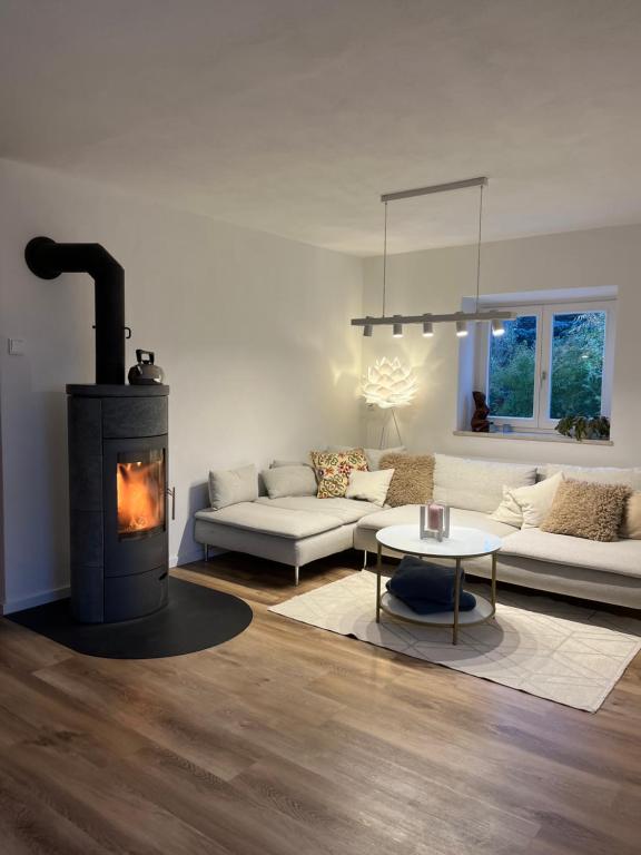 - un salon avec une cheminée, un canapé et une table dans l'établissement Home of gmiatlich - Ferien & Wohnen auf Zeit, à Mühldorf