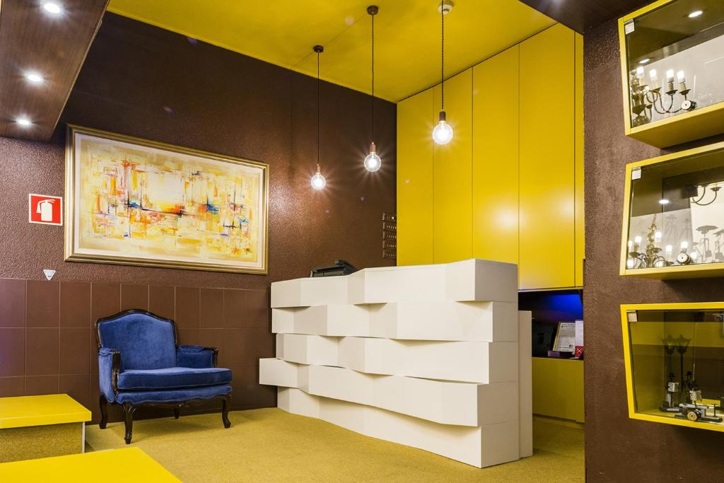 a waiting room with a blue chair and a pile of boxes at Costa do Sol B&B in Porto