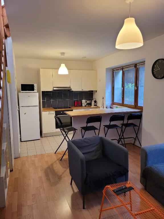 een keuken en woonkamer met een tafel en stoelen bij relais du 21 in Saint-Germain-en-Laye