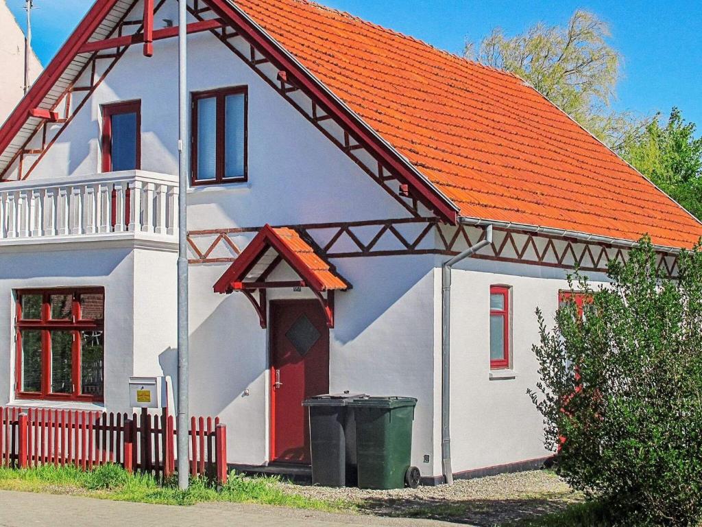 mały biały dom z pomarańczowym dachem w obiekcie Holiday home Holeby w mieście Holeby