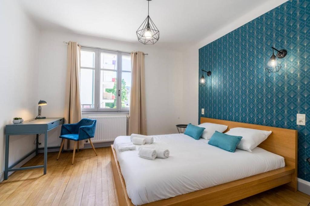 Un dormitorio con una cama grande con una pared de acento azul en Annecy Centre - Gentiane -, en Annecy