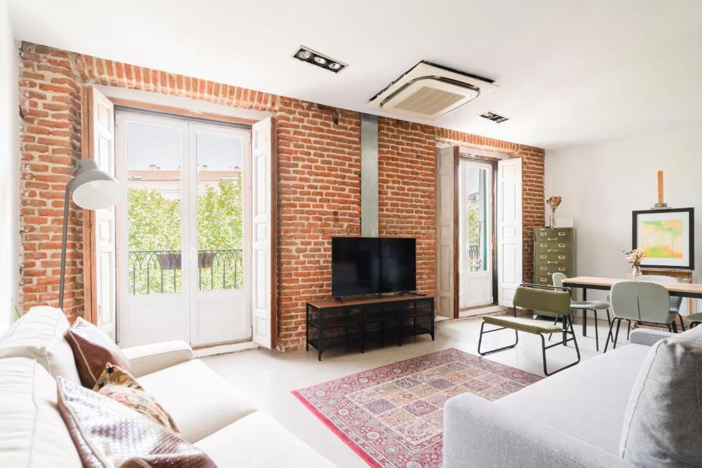 a living room with a brick wall at apartamento reformado estilo industrial plaza de tirso de molina in Madrid