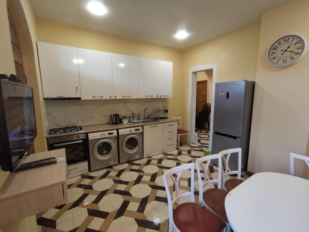 a kitchen with a refrigerator and a table with chairs at Surami Guesthouse in Surami