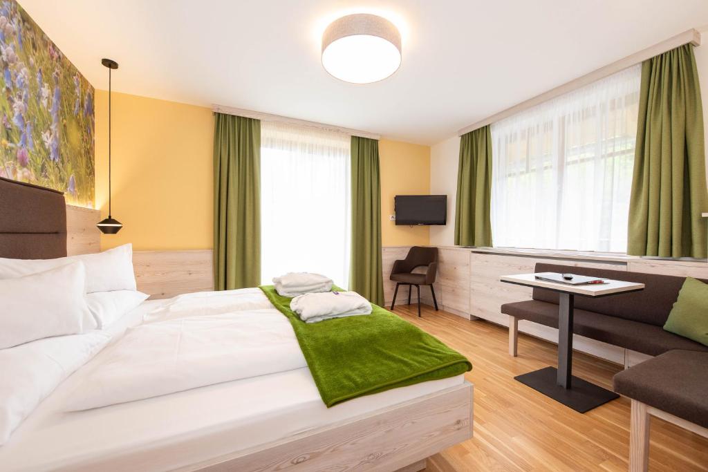 Habitación de hotel con cama grande y escritorio. en Der Almblick, en Strallegg