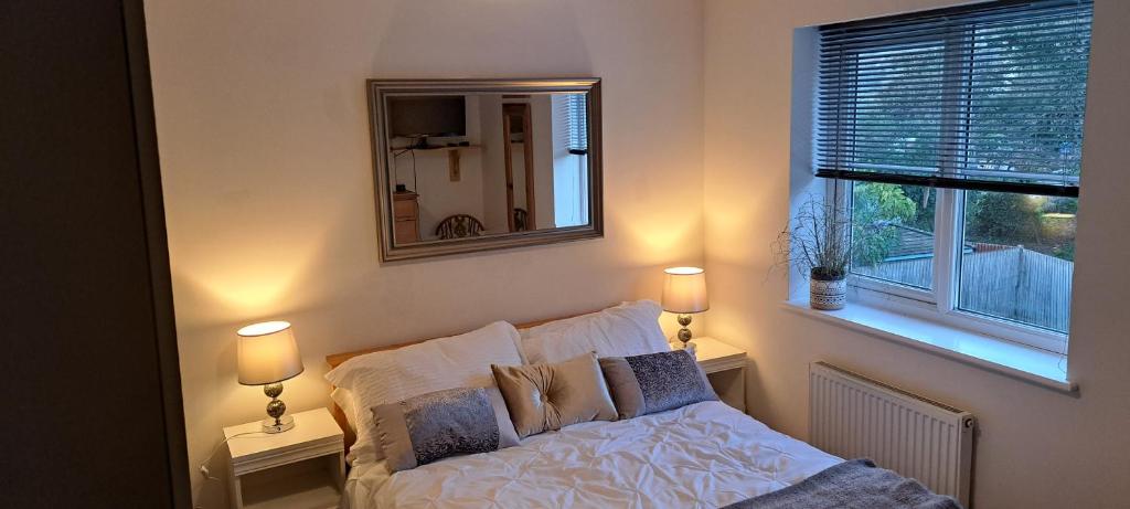 a bedroom with a bed and a mirror and a window at Cosy double room in Torquay