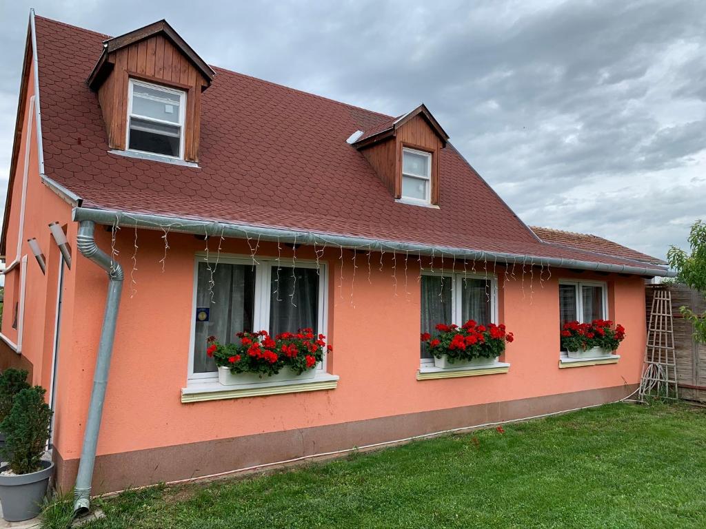 a orange house with red flowers in windows at Airport16 bed and breakfast in Budapest