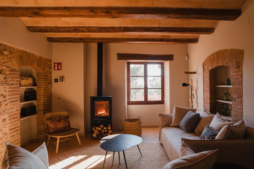a living room with a couch and a fireplace at Hotel-Masia Can Farrés in El Bruc