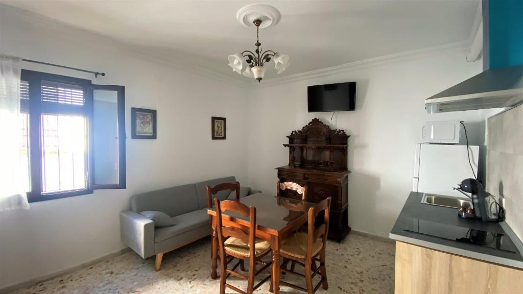 - un salon avec un canapé, une table et des chaises dans l'établissement Apartamento Doble Vacacional Carmona, à Carmona