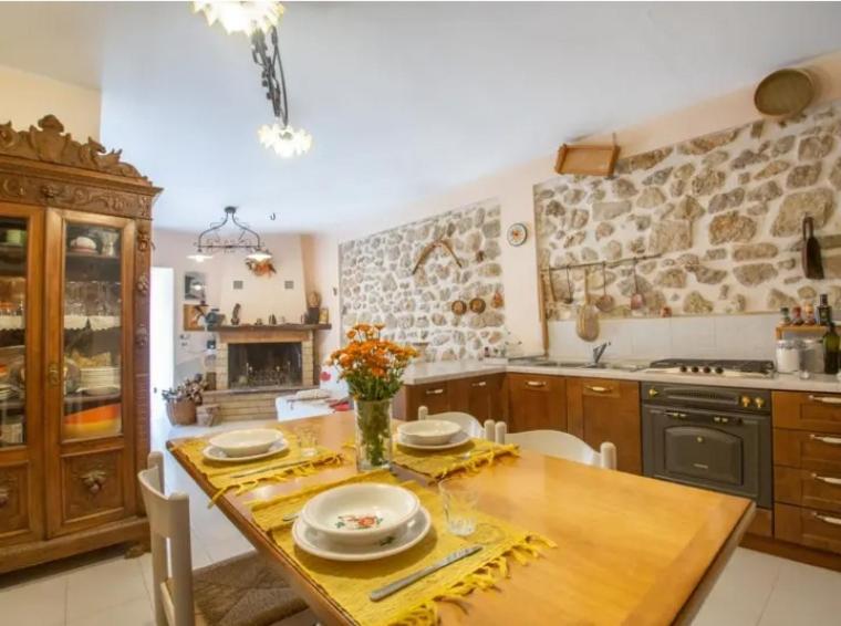 una cucina con tavolo in legno e piatti di Casa D'Aurora a Pettorano sul Gizio