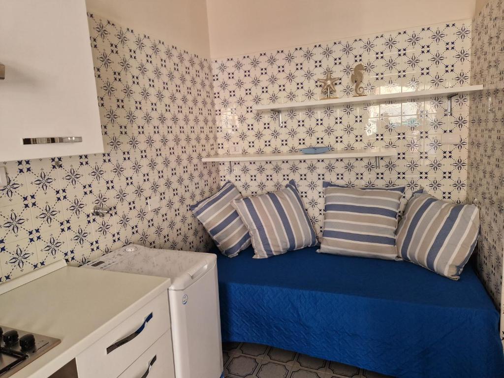 um pequeno quarto com uma cama azul com almofadas em Appartamento Luna Parcheggio gratuito em Gênova