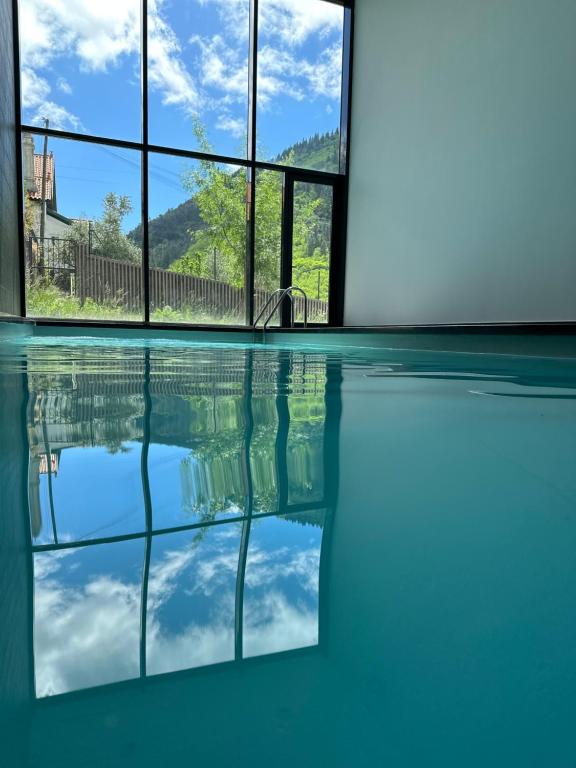 uma piscina com um reflexo do céu na água em Hotel da Fábrica em Manteigas