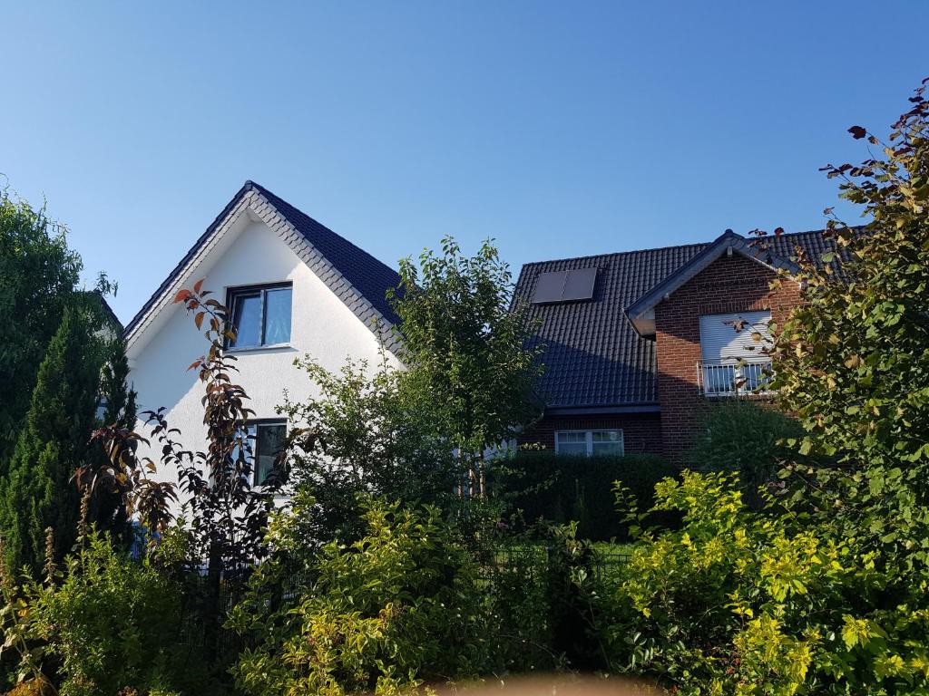 a white house with a black roof at Ferienwohnungen Liliencron - Fewo II (Ferienhaus) in Enger