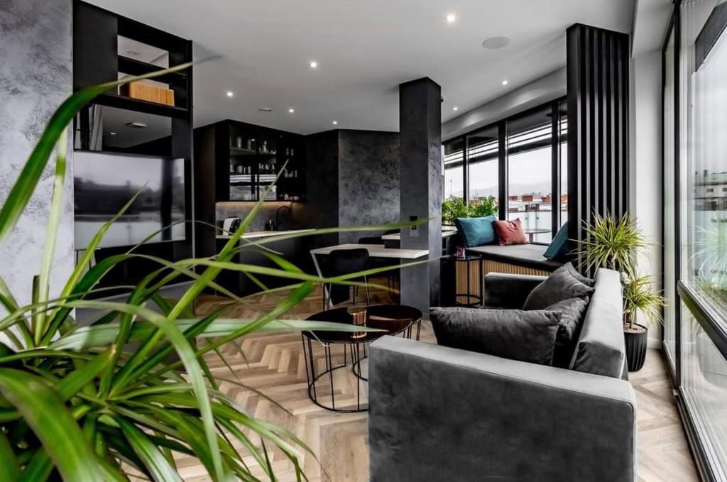 a living room with chairs and tables and plants at Moon Apartment in Bielsko-Biała