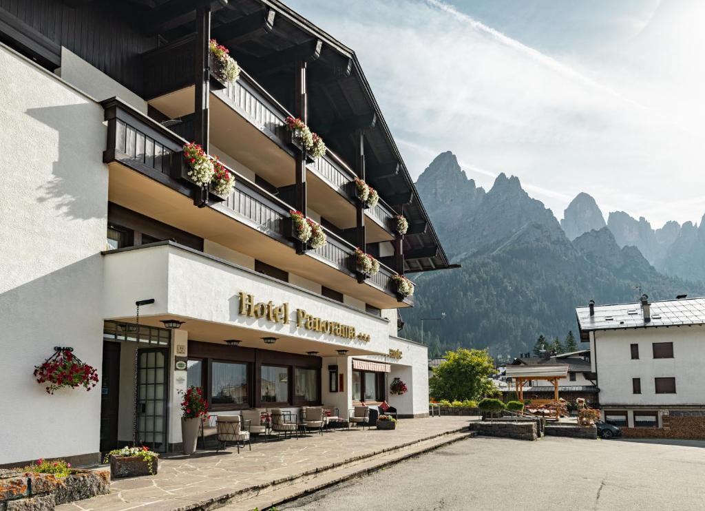 a hotel with the mountains in the background at Hotel Panorama in San Martino di Castrozza