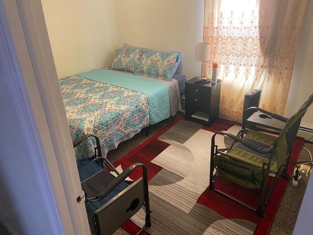 een kleine slaapkamer met een bed en een stoel bij Mo Short Term Rentals in Mount Vernon