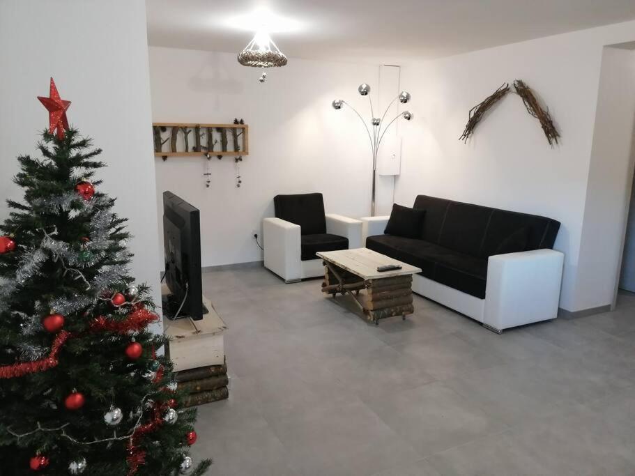 - un salon avec un arbre de Noël et un canapé dans l'établissement Belle appartement style chalet, à Gérardmer