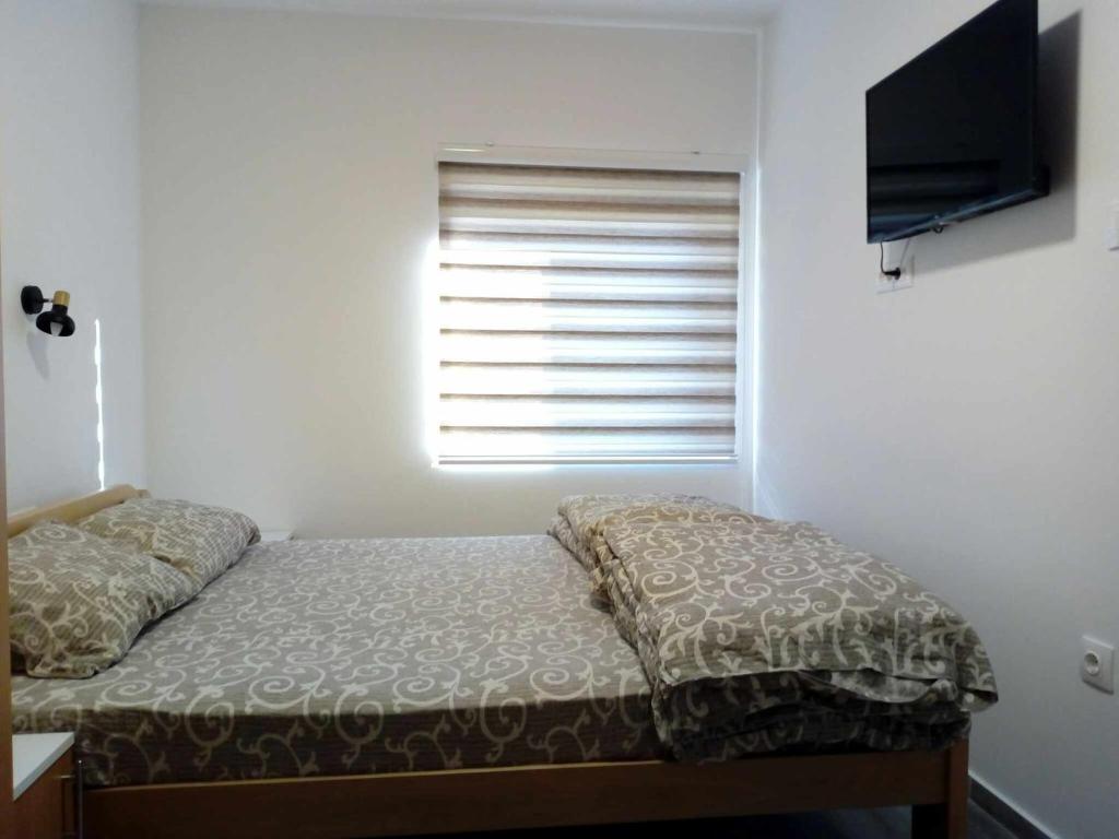 a small bedroom with a bed and a window at STD Cvetković in Crni Vrh