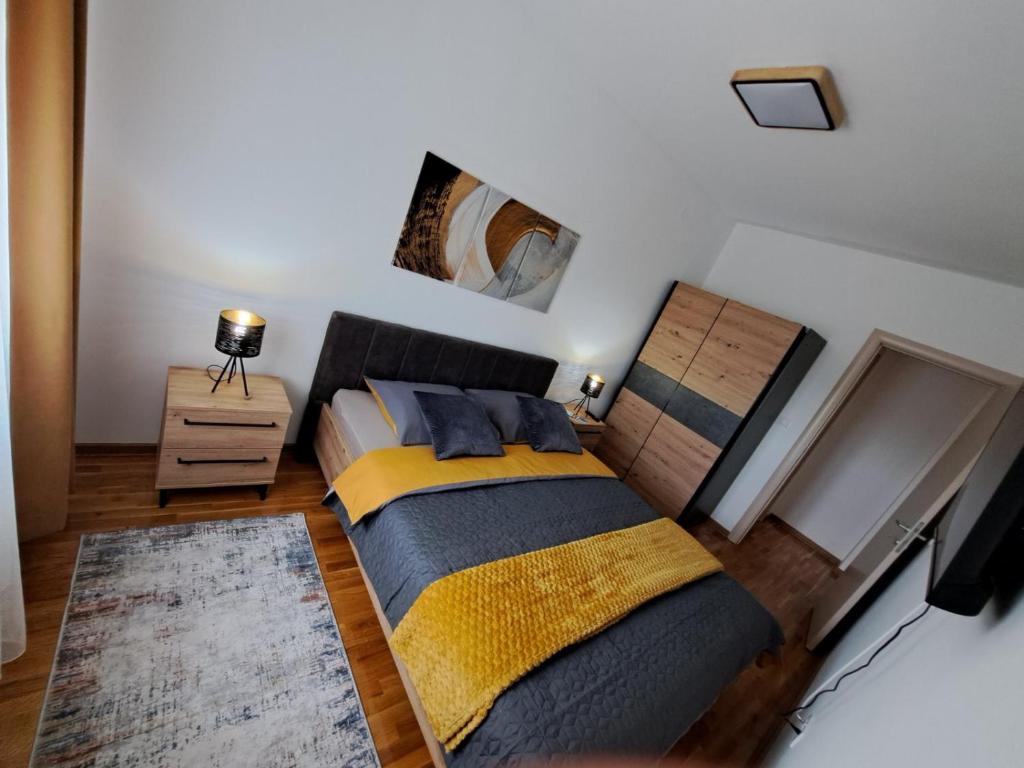 Schlafzimmer mit einem Bett und einem Wandspiegel in der Unterkunft LUX APARTMAN PANORAMA in Bečej