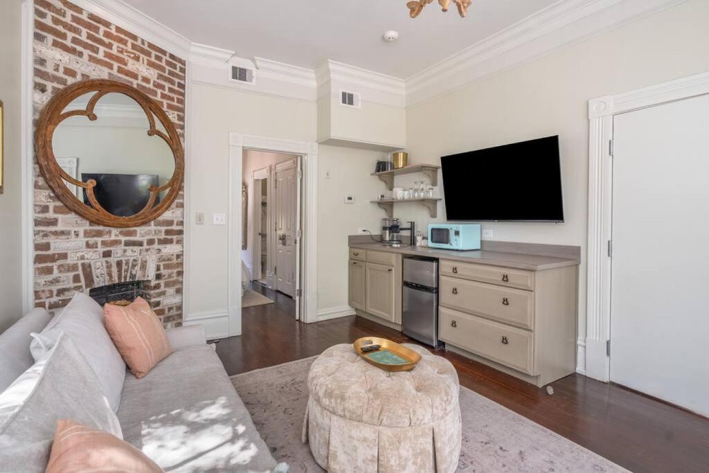 uma sala de estar com um sofá e uma televisão em Leland Suite at Mirabelle em Savannah
