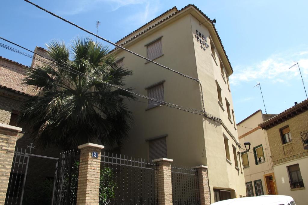 un edificio con una palmera delante de él en Hostal Casa Pepe, en Tauste