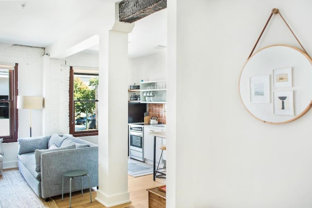 a living room with a couch and a mirror at Roomy Hip 2BR in Savannah in Savannah