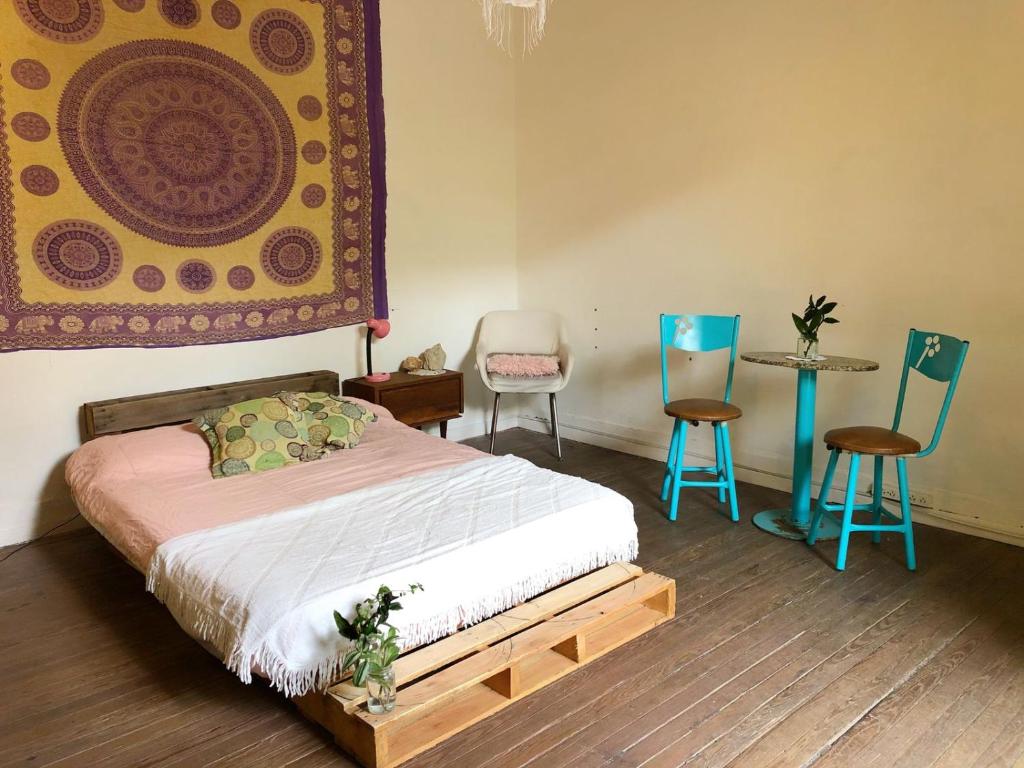 a bedroom with a bed and two chairs and a table at CASA QUEER in Buenos Aires