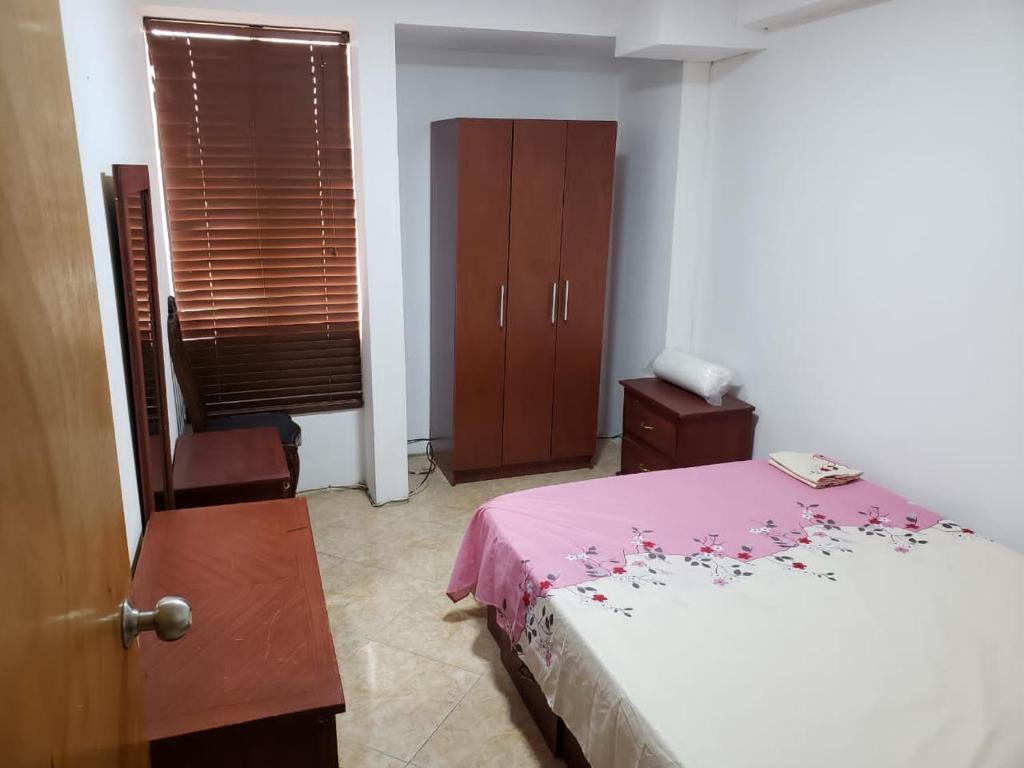 1 dormitorio con 1 cama, 1 silla y 1 ventana en Apartamento los caobos, en Caracas