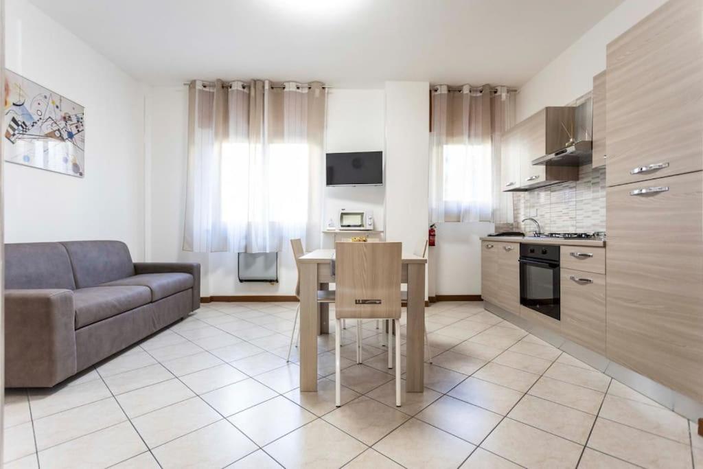 eine Küche und ein Wohnzimmer mit einem Tisch und einem Sofa in der Unterkunft Ca' Ida - Affitti Temporanei in Turin