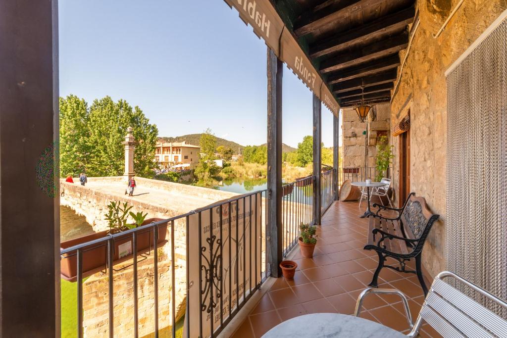 a balcony with chairs and a view of a river at Fonda la Plaza in Valderrobres