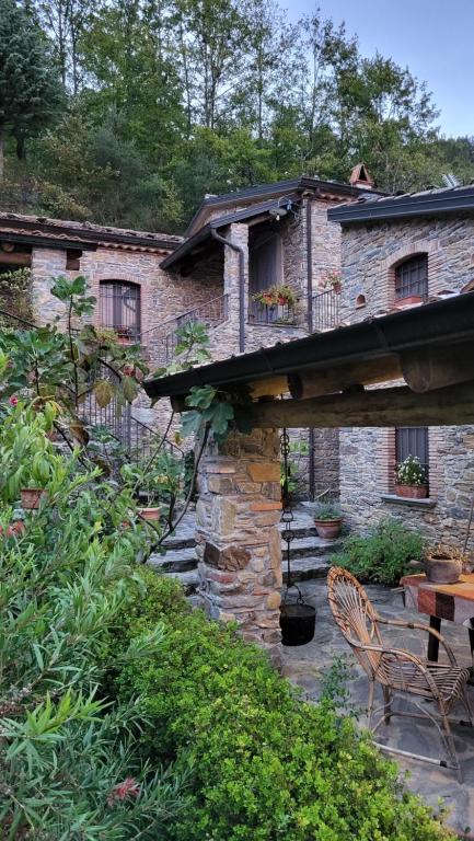 a stone house with a table and chairs on a patio at Case Vacanza S. Nicola in Viggianello