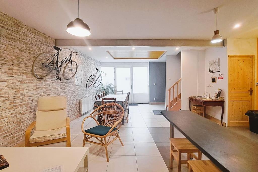 a room with a table and chairs and a bike on the wall at Gite étape pour amoureux du vélo Azay centre 12p. in Azay-le-Rideau