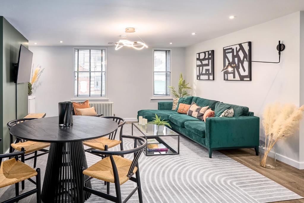 a living room with a green couch and a table at Be London - Chinatown Residences in London