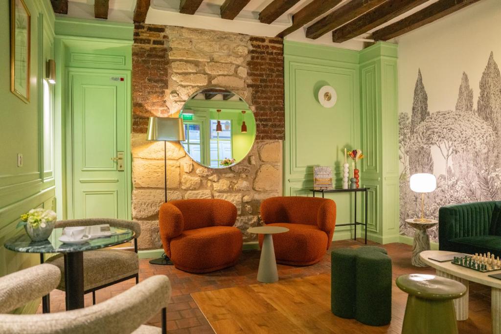 - une salle d'attente avec des chaises et un miroir dans l'établissement Hôtel De Fleurie, à Paris