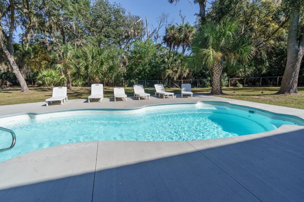 a swimming pool with lounge chairs and a pool at Edisto Hidden Oasis in Edisto Island