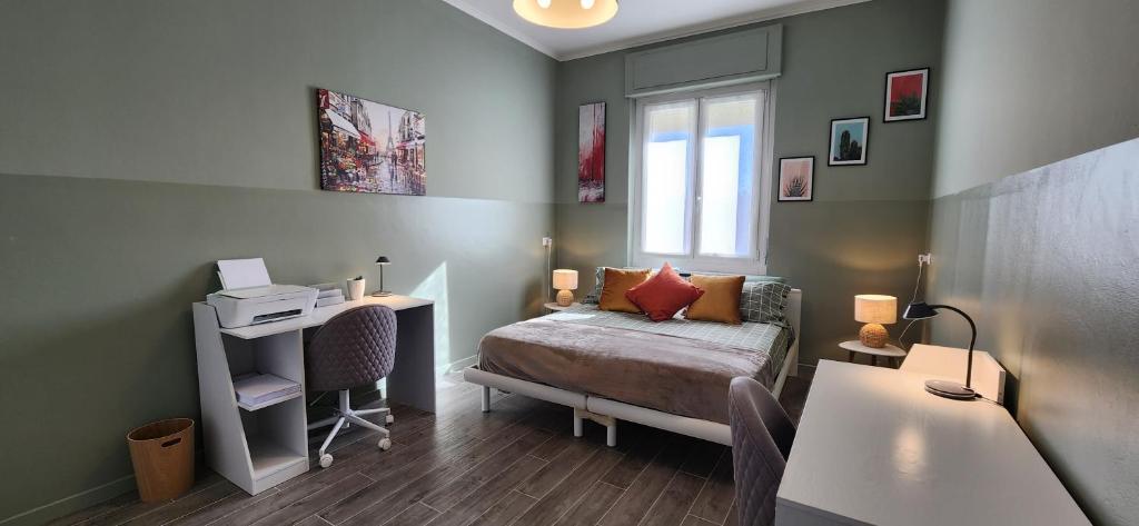 Schlafzimmer mit einem Bett, einem Schreibtisch und einem Fenster in der Unterkunft Sunshine House in Alessandria