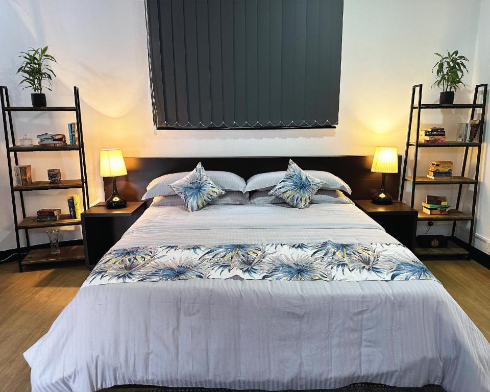 - une chambre avec un grand lit blanc et des oreillers bleus dans l'établissement Aadaraya Colombo 7, à Colombo
