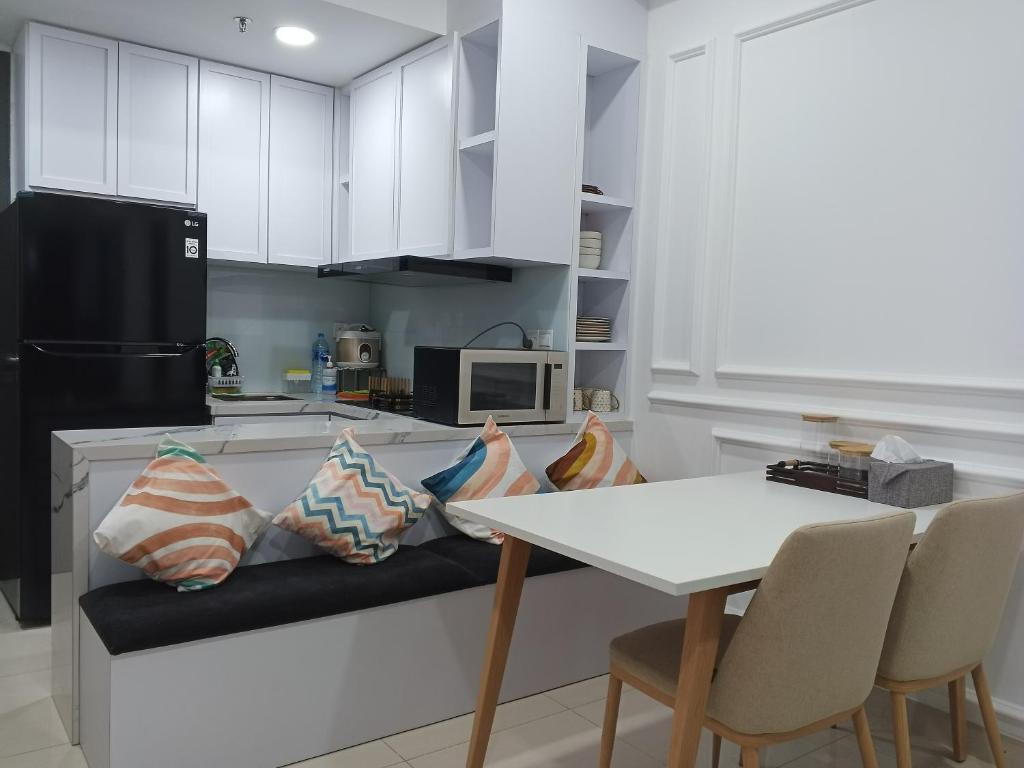a kitchen with a counter with a table and chairs at Peaceful Sea view Cozy APT at Batam Center - By MESA in Batam Center