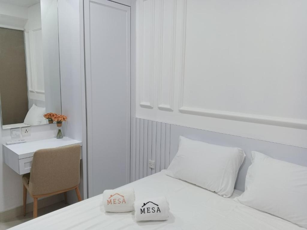 a white bedroom with a bed and a desk at Peaceful Sea view Cozy APT at Batam Center - By MESA in Batam Center